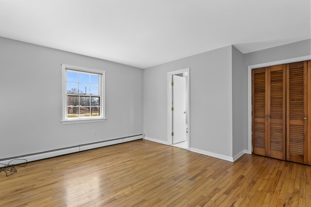 285 Greens Farms Rd, Westport, CT 06880 - unfurnished bedroom featuring a baseboard radiator, light wood-type flooring, a closet, and baseboards