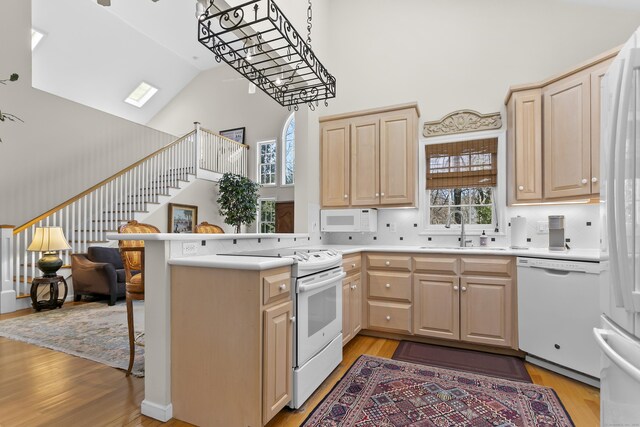 285 Greens Farms Rd, Westport, CT 06880 - kitchen featuring a sink, white appliances, light brown cabinetry, high vaulted ceiling, and light wood-style flooring