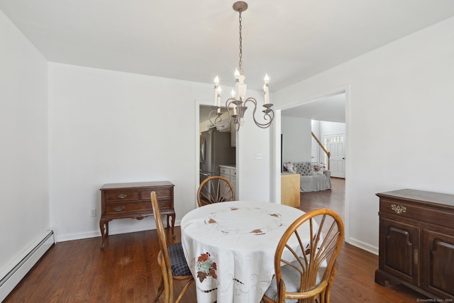 dining area with a baseboard heating unit, baseboards, dark wood-type flooring, a notable chandelier, and stairs