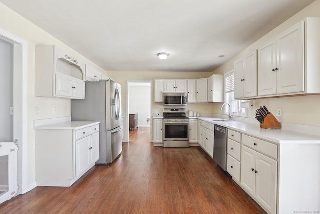 kitchen with white cabinets, dark wood-style flooring, appliances with stainless steel finishes, and a sink
