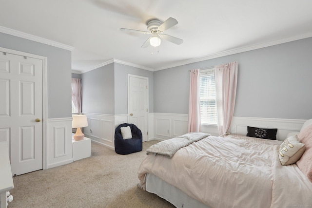 bedroom featuring ornamental molding, ceiling fan, wainscoting, and carpet floors