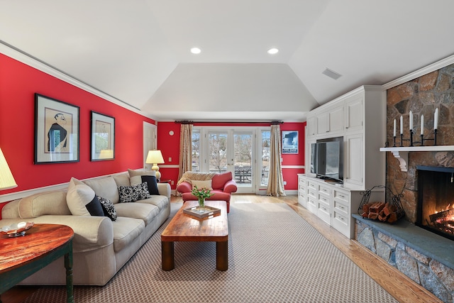 living room featuring visible vents, light wood-style floors, a fireplace, french doors, and lofted ceiling