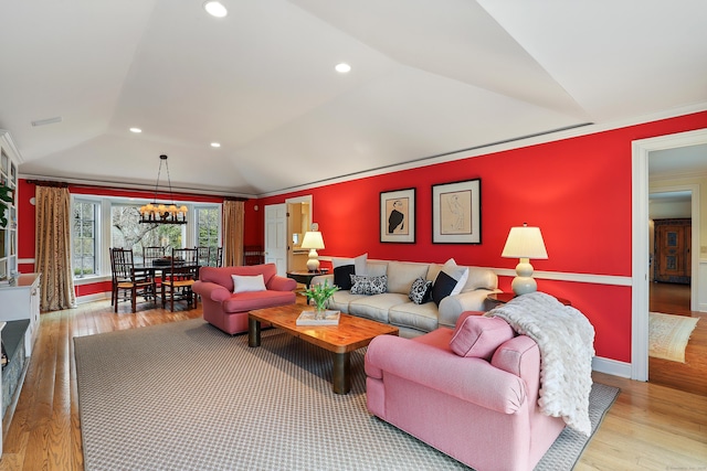 living room with ornamental molding, vaulted ceiling, recessed lighting, wood finished floors, and a raised ceiling