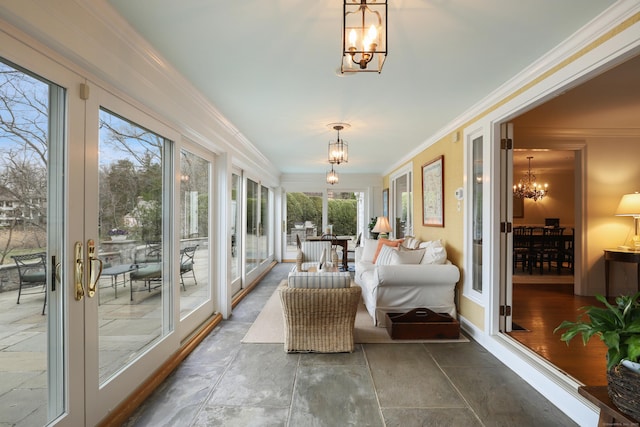 sunroom / solarium with an inviting chandelier and ornamental molding