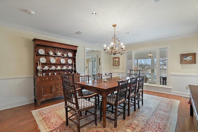 dining room featuring baseboards, an inviting chandelier, ornamental molding, recessed lighting, and wood finished floors