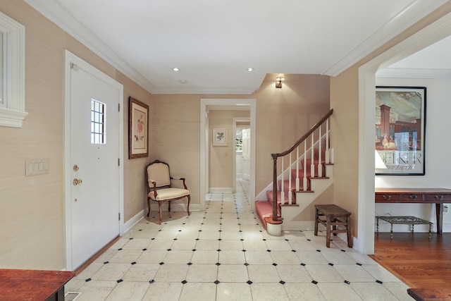 foyer entrance featuring crown molding, stairs, baseboards, and tile patterned floors