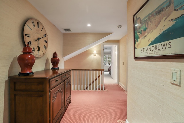 corridor featuring visible vents, an upstairs landing, and carpet