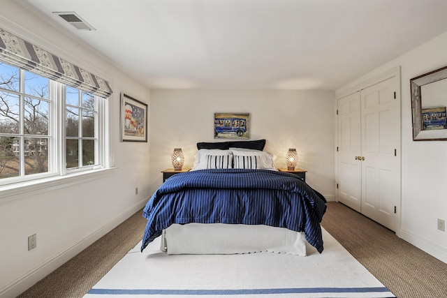 bedroom with a closet, visible vents, and baseboards