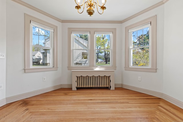 unfurnished dining area with a chandelier, a healthy amount of sunlight, crown molding, and radiator
