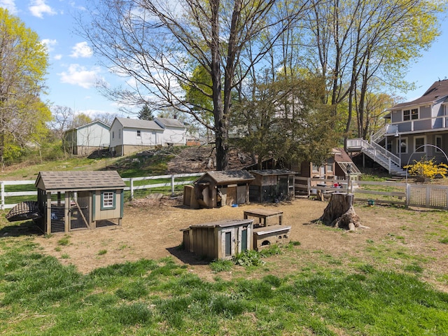 view of yard with fence, an outdoor structure, and exterior structure