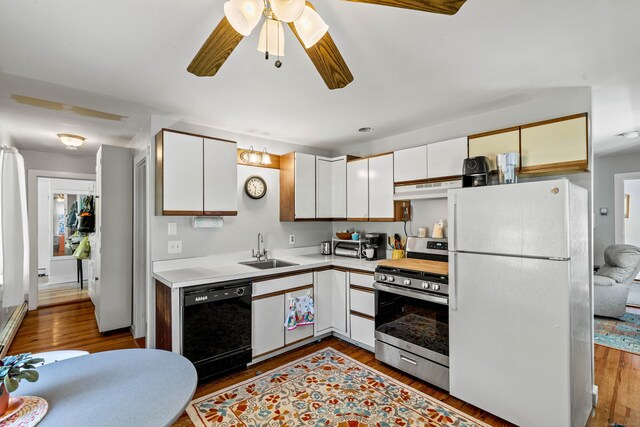 kitchen featuring stainless steel range with gas cooktop, light countertops, freestanding refrigerator, under cabinet range hood, and black dishwasher