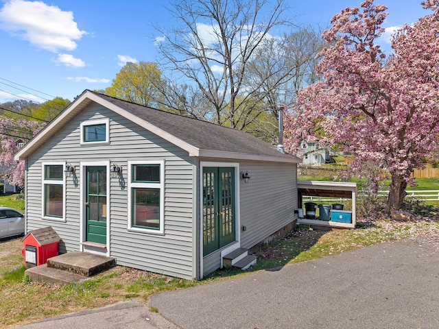 exterior space featuring a shingled roof and entry steps