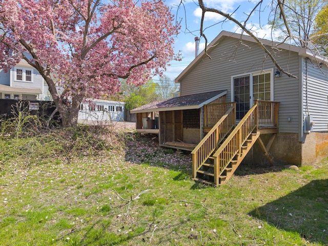 rear view of house with a sunroom and a lawn