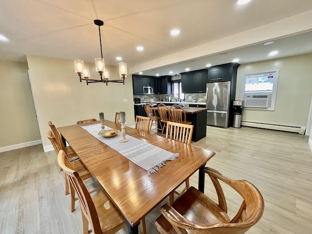 dining space with light wood-style flooring, a chandelier, a baseboard heating unit, and recessed lighting