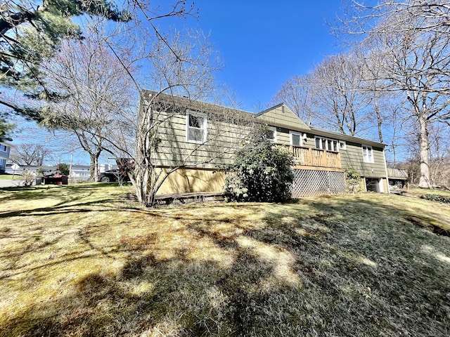 view of property exterior with a yard and a wooden deck