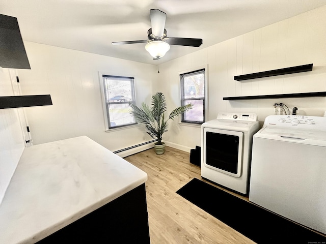 washroom featuring light wood-type flooring, baseboards, washer and clothes dryer, ceiling fan, and a baseboard radiator