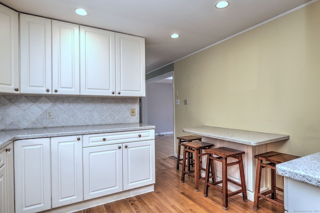 137 Harding Ave, West Haven, CT 06516 - kitchen with recessed lighting, white cabinetry, light wood-style flooring, tasteful backsplash, and ornamental molding