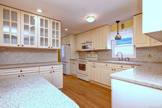 137 Harding Ave, West Haven, CT 06516 - kitchen featuring white appliances, a sink, backsplash, light wood-type flooring, and hanging light fixtures