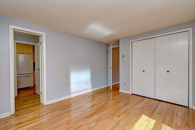 137 Harding Ave, West Haven, CT 06516 - unfurnished bedroom featuring freestanding refrigerator, light wood finished floors, a closet, and baseboards