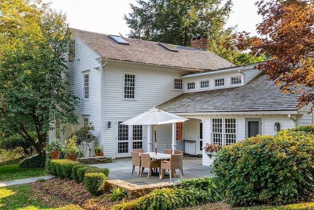 back of property featuring a patio and a chimney
