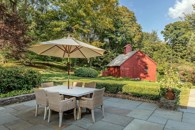 view of patio featuring an outdoor structure and outdoor dining space