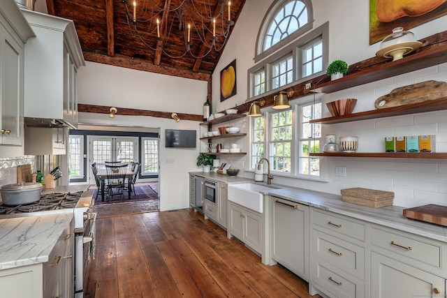 kitchen with dark wood-style flooring, tasteful backsplash, open shelves, a sink, and stainless steel gas range