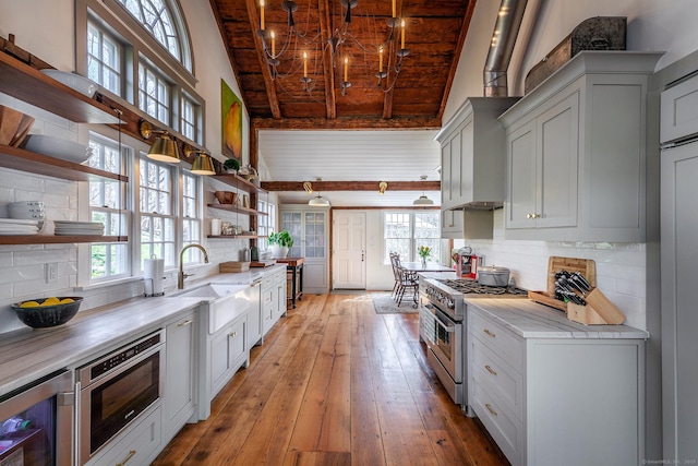 kitchen with open shelves, a sink, high vaulted ceiling, high end range, and wooden ceiling