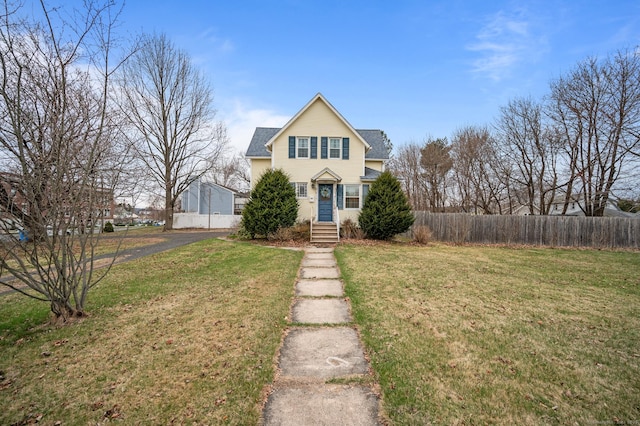 traditional home featuring fence and a front lawn