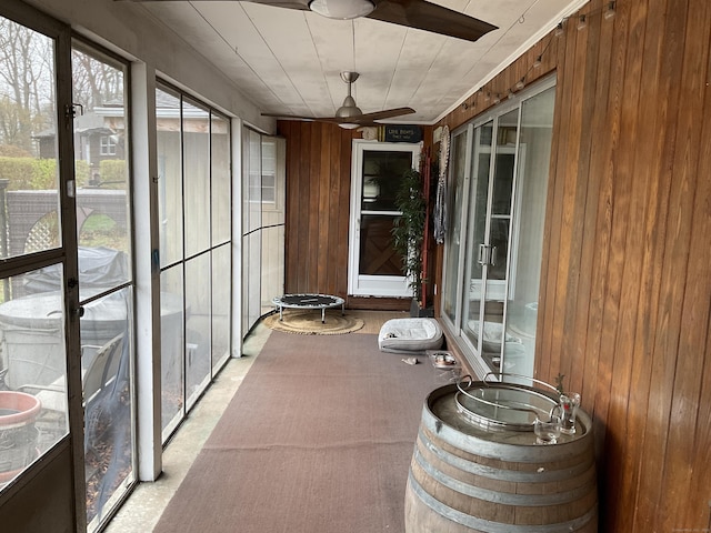 unfurnished sunroom with ceiling fan