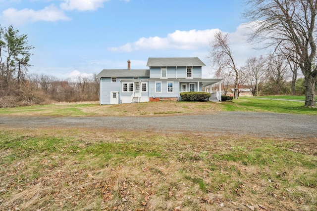 view of front of house with a front yard and a chimney
