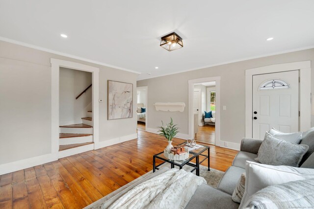 living room featuring stairway, light wood-type flooring, crown molding, and recessed lighting