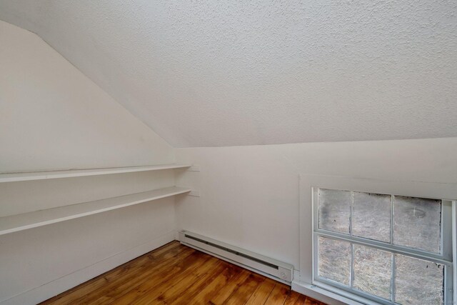 interior space featuring a baseboard radiator, wood finished floors, and a textured ceiling