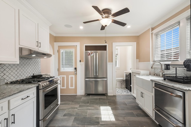 37 Dale Rd, Wethersfield, CT 06109 - kitchen with appliances with stainless steel finishes, under cabinet range hood, a ceiling fan, white cabinets, and a wainscoted wall