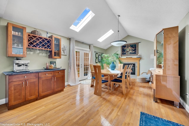 38 Benjamin Rd, East Haven, CT 06513 - dining area featuring a glass covered fireplace, baseboards, vaulted ceiling, and light wood finished floors