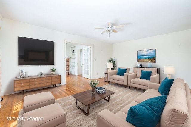 living area with a ceiling fan and light wood-type flooring
