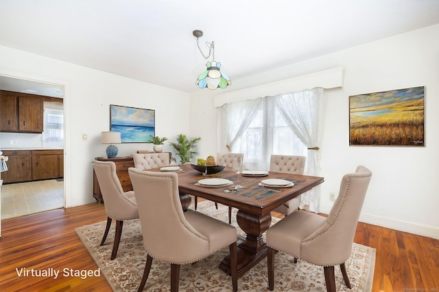 dining area featuring light wood-style floors and baseboards