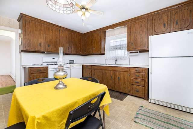kitchen featuring a ceiling fan, white appliances, light countertops, a sink, and backsplash