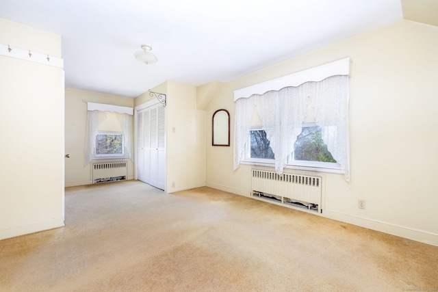 spare room featuring baseboards, carpet, and radiator heating unit