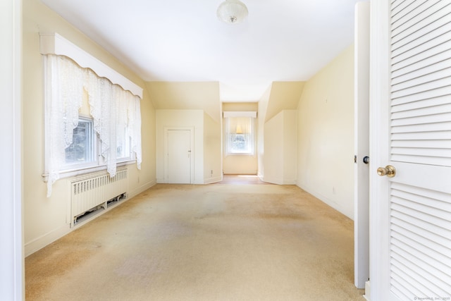bonus room featuring carpet floors, baseboards, a healthy amount of sunlight, and radiator heating unit