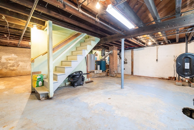 unfinished below grade area with stairway, gas water heater, and heating fuel