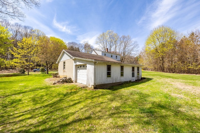 view of side of home with a garage, a yard, and a chimney