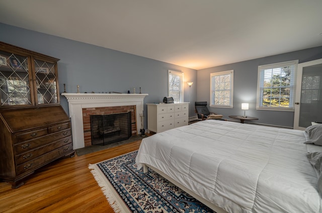 bedroom featuring wood finished floors and a fireplace