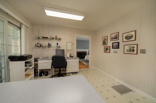 office area with baseboards, tile patterned floors, and a fireplace