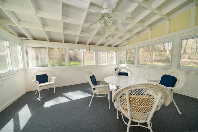 sunroom featuring carpet floors, outdoor dining space, a ceiling fan, and lofted ceiling with beams