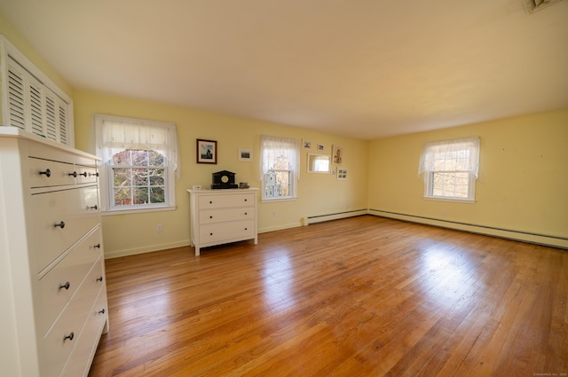 unfurnished bedroom with baseboards, multiple windows, and light wood finished floors