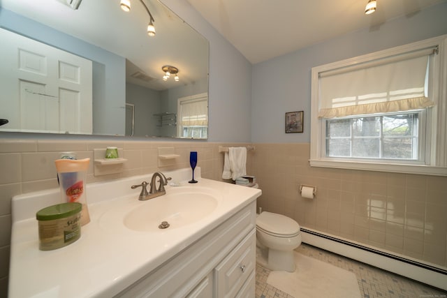 bathroom featuring tile walls, plenty of natural light, vanity, and a baseboard radiator