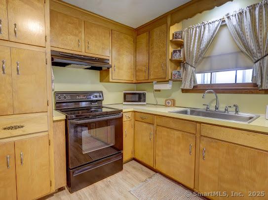 67 Stuart St, Newington, CT 06111 - kitchen featuring black / electric stove, under cabinet range hood, a sink, light wood finished floors, and light countertops