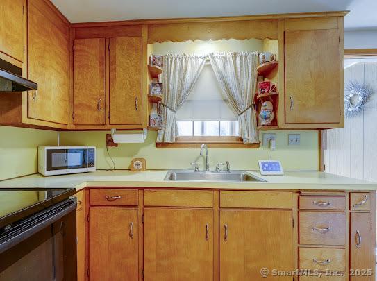 67 Stuart St, Newington, CT 06111 - kitchen with stainless steel microwave, a sink, light countertops, and black range with electric stovetop