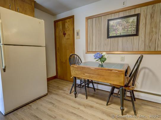 dining space featuring baseboards and light wood-style flooring
