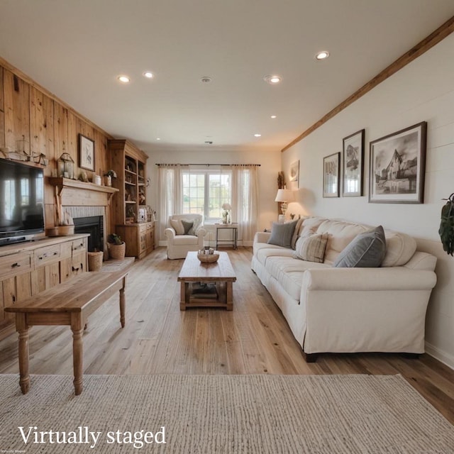 living room with crown molding, light wood-style floors, a brick fireplace, and recessed lighting